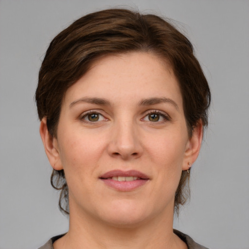 Joyful white young-adult female with medium  brown hair and grey eyes