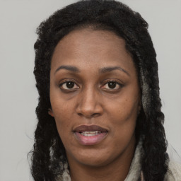 Joyful black young-adult female with long  brown hair and brown eyes