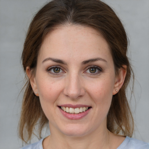 Joyful white young-adult female with medium  brown hair and grey eyes