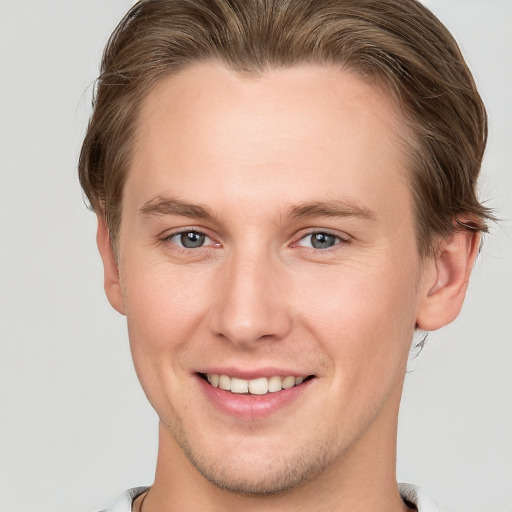 Joyful white young-adult male with short  brown hair and grey eyes