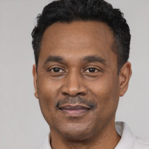Joyful latino adult male with short  black hair and brown eyes