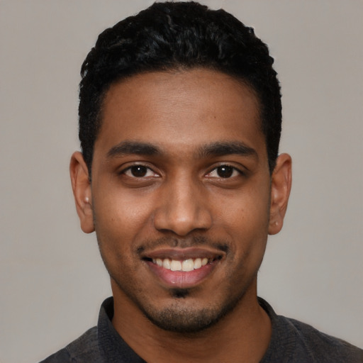 Joyful black young-adult male with short  black hair and brown eyes