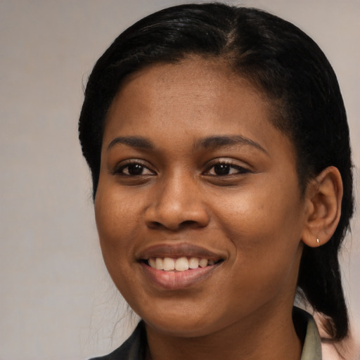 Joyful black young-adult female with long  black hair and brown eyes