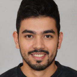 Joyful latino young-adult male with short  black hair and brown eyes