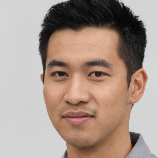 Joyful asian young-adult male with short  black hair and brown eyes