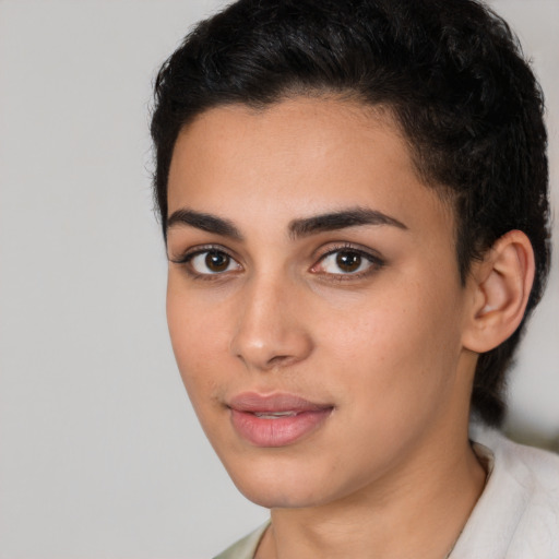 Joyful latino young-adult female with short  black hair and brown eyes