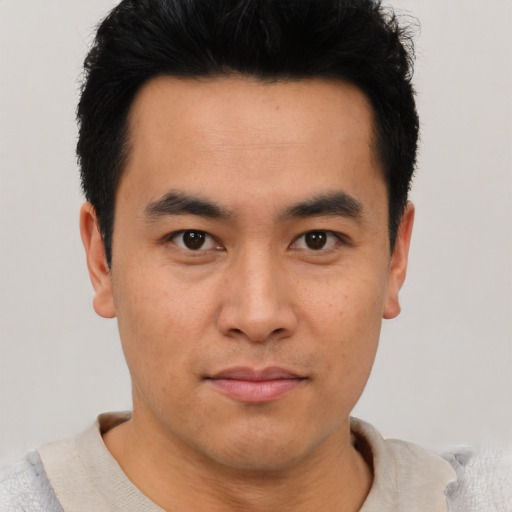 Joyful asian young-adult male with short  brown hair and brown eyes