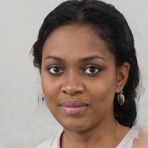 Joyful black young-adult female with medium  black hair and brown eyes