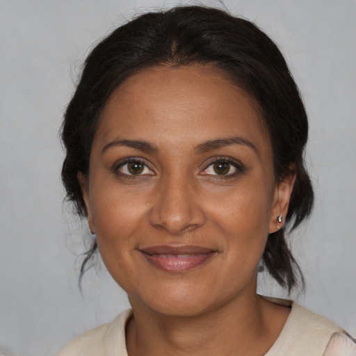 Joyful black adult female with medium  brown hair and brown eyes