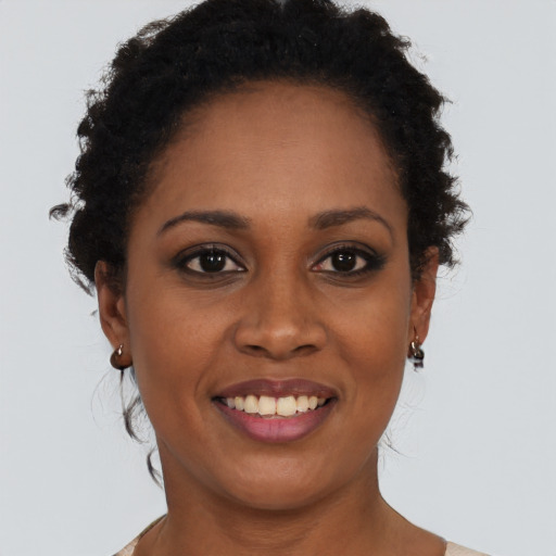 Joyful black young-adult female with short  black hair and brown eyes