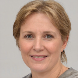 Joyful white adult female with medium  brown hair and blue eyes