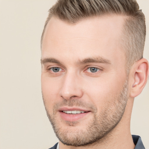 Joyful white young-adult male with short  brown hair and grey eyes