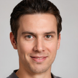 Joyful white young-adult male with short  brown hair and grey eyes