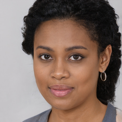 Joyful black young-adult female with long  black hair and brown eyes