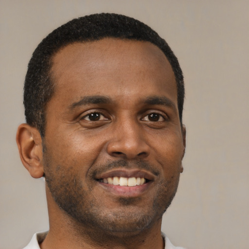 Joyful black young-adult male with short  black hair and brown eyes