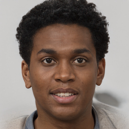 Joyful black young-adult male with short  brown hair and brown eyes
