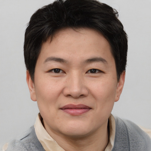 Joyful asian adult male with short  brown hair and brown eyes