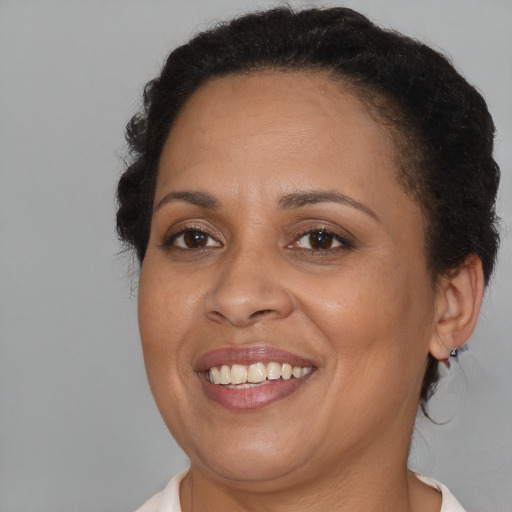 Joyful black adult female with short  brown hair and brown eyes