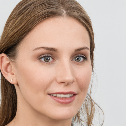 Joyful white young-adult female with long  brown hair and blue eyes