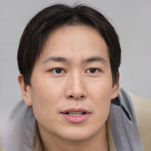 Joyful asian young-adult male with short  brown hair and brown eyes