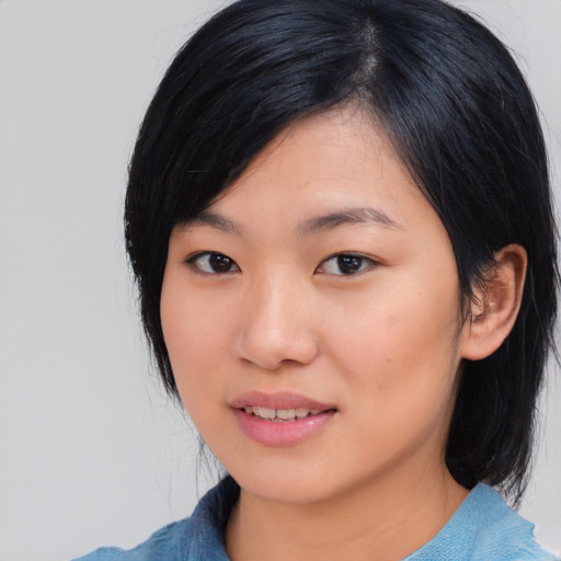 Joyful asian young-adult female with medium  black hair and brown eyes