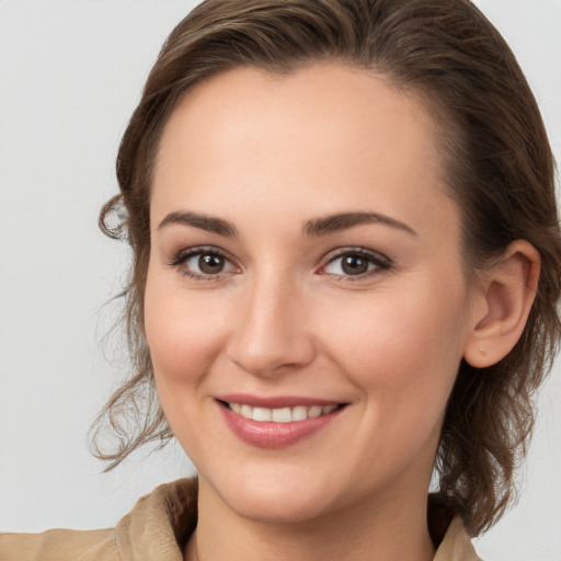 Joyful white young-adult female with medium  brown hair and grey eyes