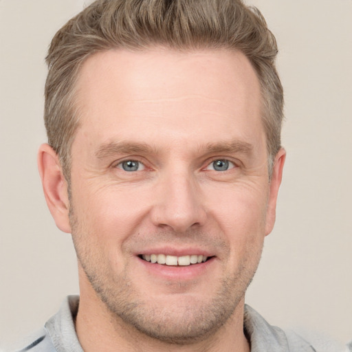 Joyful white adult male with short  brown hair and grey eyes