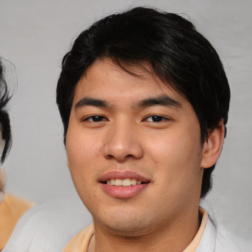 Joyful asian young-adult male with medium  black hair and brown eyes