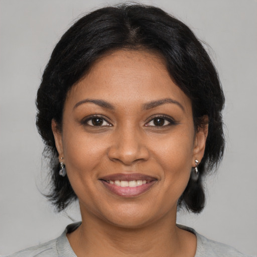 Joyful black young-adult female with medium  black hair and brown eyes