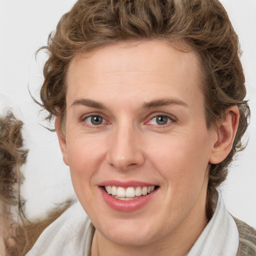 Joyful white adult female with medium  brown hair and green eyes