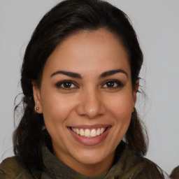 Joyful latino young-adult female with medium  brown hair and brown eyes