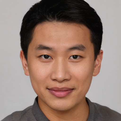 Joyful asian young-adult male with short  brown hair and brown eyes