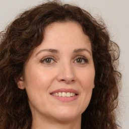 Joyful white young-adult female with long  brown hair and green eyes