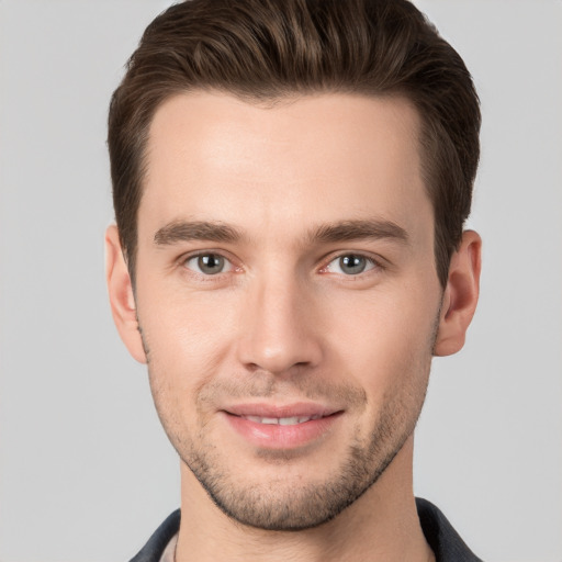 Joyful white young-adult male with short  brown hair and grey eyes