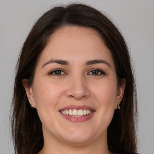 Joyful white young-adult female with long  brown hair and brown eyes