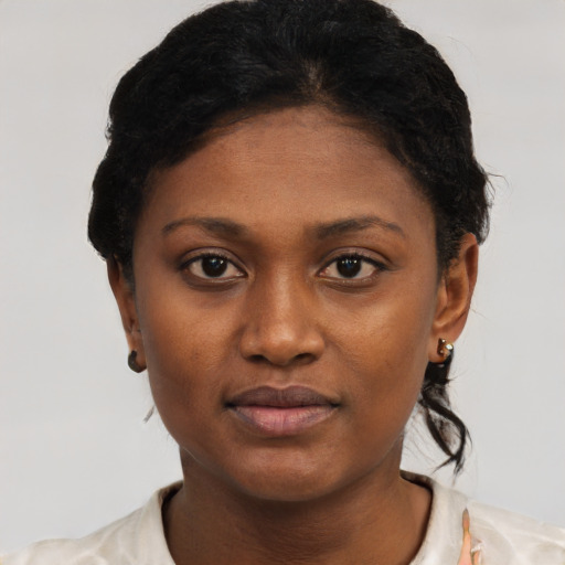 Joyful black young-adult female with short  black hair and brown eyes