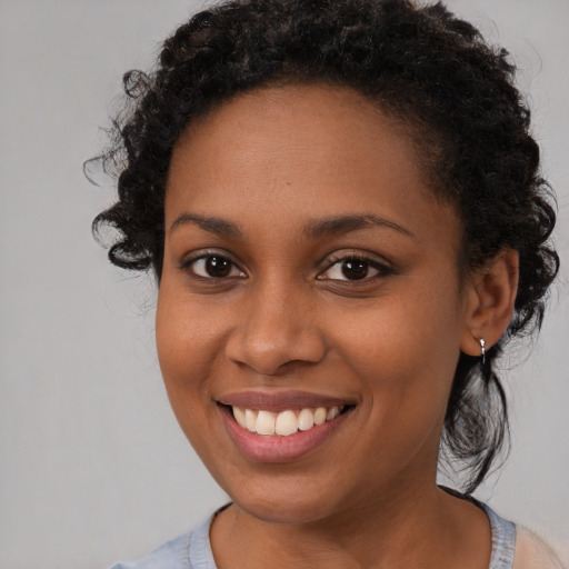 Joyful black young-adult female with medium  brown hair and brown eyes