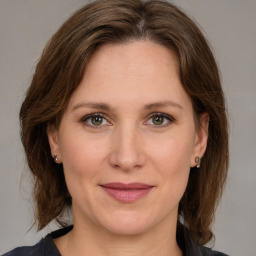 Joyful white adult female with medium  brown hair and green eyes