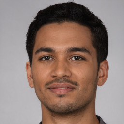 Joyful latino young-adult male with short  brown hair and brown eyes