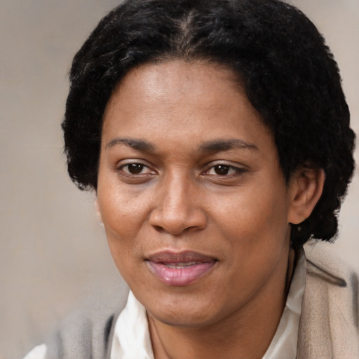 Joyful black adult female with short  black hair and brown eyes