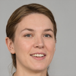 Joyful white adult female with medium  brown hair and grey eyes