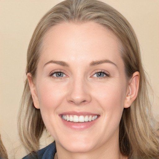 Joyful white adult female with long  brown hair and blue eyes