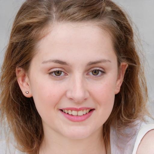 Joyful white young-adult female with long  brown hair and blue eyes