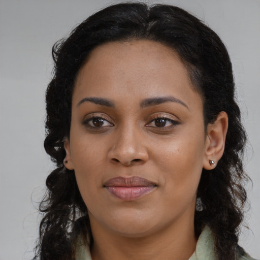 Joyful black young-adult female with long  brown hair and brown eyes