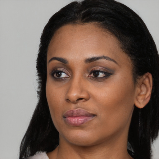 Joyful black young-adult female with long  black hair and brown eyes