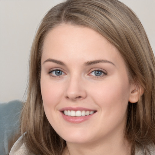 Joyful white young-adult female with long  brown hair and grey eyes