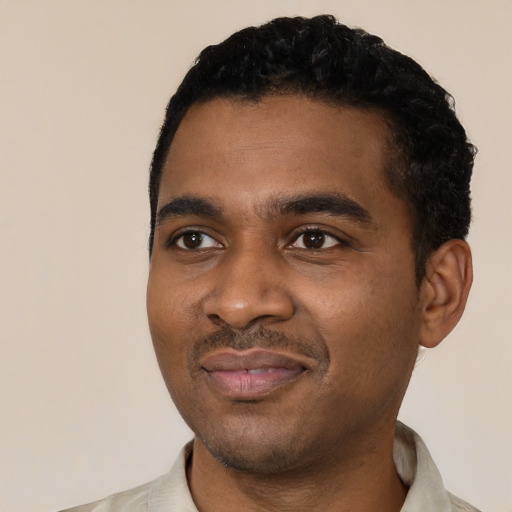 Joyful black young-adult male with short  black hair and brown eyes