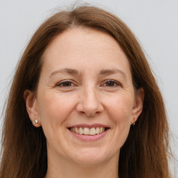 Joyful white adult female with long  brown hair and grey eyes