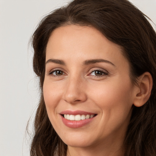 Joyful white young-adult female with long  brown hair and brown eyes