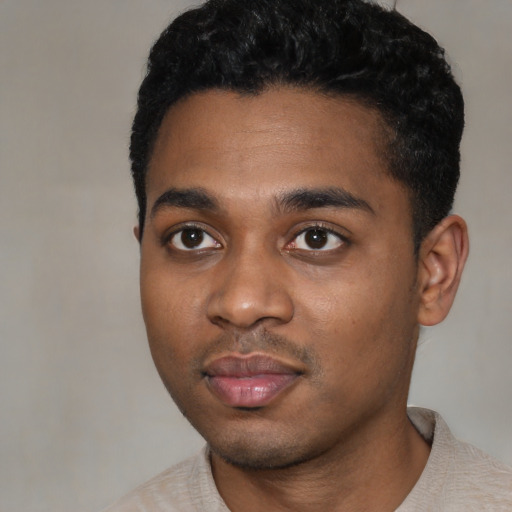 Joyful black young-adult male with short  black hair and brown eyes